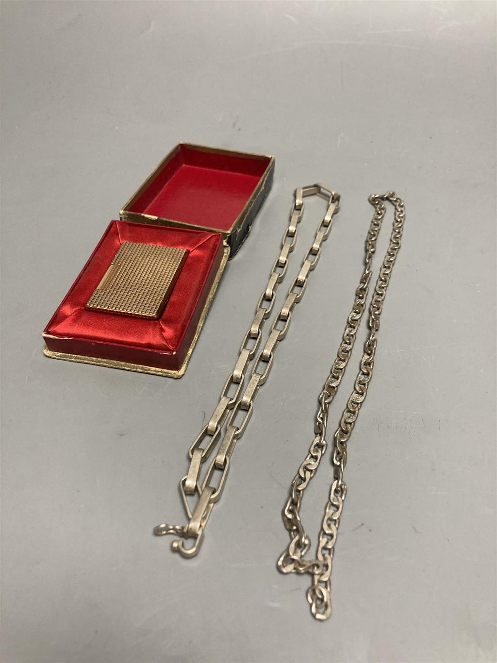 An S. T. Dupont, Paris gold-plated cigarette lighter (20 mu), original box and two white metal chain-link necklaces